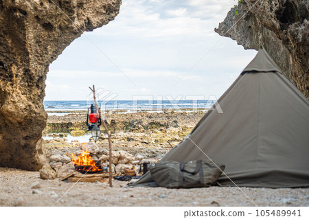 camping solo camp one person camp tent setup sea seaside bonfire rocky place copy space 105489941