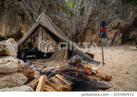 camping bushcraft rugged rocky area adventure tent construction one person camping solo camp bonfire 105490413