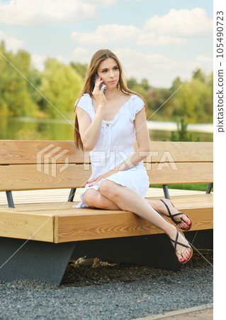 Serious phone call distracted woman relaxing in park Serious phone call distracted woman relaxing in park 105490723