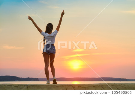 Cute woman meets sunset on a pier Cute woman meets sunset on a pier 105490805