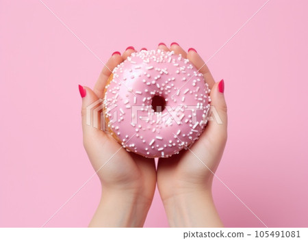 Female hand with pink donut on minimalist background 105491081