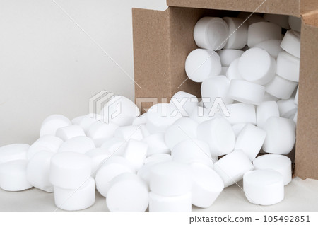 Lying part of a box with scattered pressed dishwasher salt side view close-up. Place for text Lying part of a box with scattered pressed dishwasher salt side view close-up. Place for text 105492851