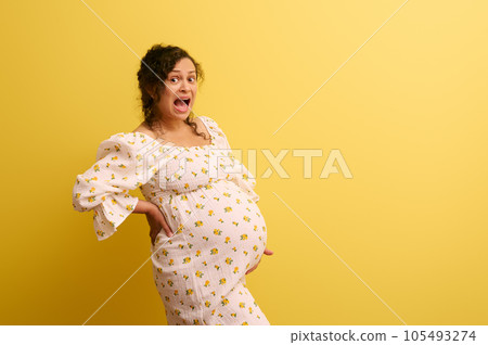 Stupefied pregnant woman holding belly, crying and shouting looking at camera. Easy delivery, pregnancy and parturition 105493274