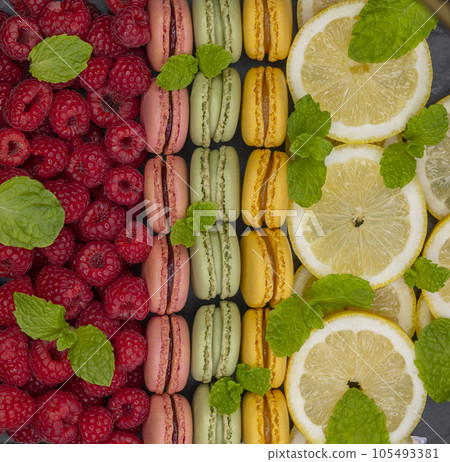 macaroons of different colors with with raspberries, lemon and mint 105493381