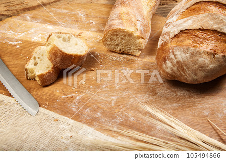 Freshly baked crispy and toasted ciabatta bread sliced on wooden cutting board. Freshly baked crispy and toasted ciabatta bread sliced on wooden cutting board. 105494866