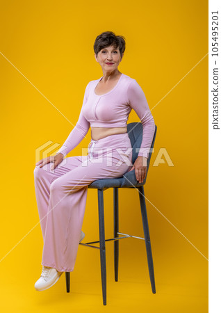 Pretty senior woman in pink looking happy and smiling Pretty senior woman in pink looking happy and smiling 105495201