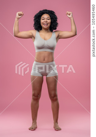 Athletic woman in lingerie standing on pink background Athletic woman in lingerie standing on pink background 105495460