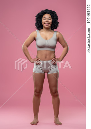 Athletic woman in lingerie standing on pink background 105495462