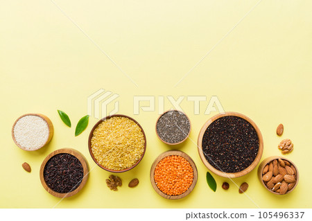 Various superfoods in smal bowl on colored background. Superfood as rice, chia, quinoa, lentils, nuts, sesame seeds, almonds. top view copy space Various superfoods in smal bowl on colored background. Superfood as rice, chia, quinoa, lentils, nuts, sesame seeds, almonds. top view copy space 105496337