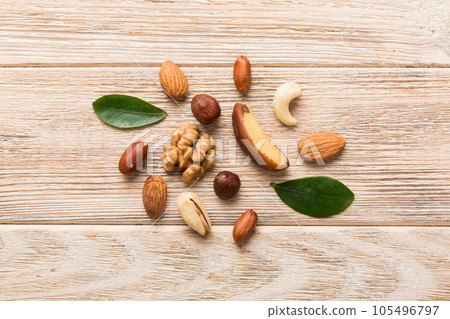 Composition of nuts , flat lay - mix hazelnuts, cashews, almonds on table background. healthy eating concepts and food background Composition of nuts , flat lay - mix hazelnuts, cashews, almonds on table background. healthy eating concepts and food background 105496797