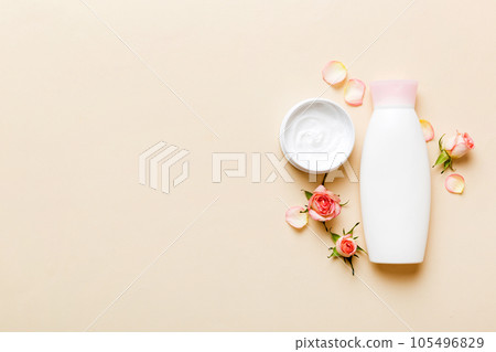 Fancy healthcare bottles for cream with rose flower. Natural oranic spa cosmetics concept. Mockup, template, Top view 105496829