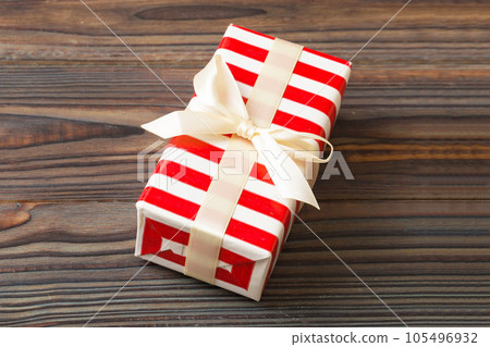 Wrapped christmas or other holiday handmade present in paper with colored ribbon. Present box, decoration of gift on table, top view with copy space Wrapped christmas or other holiday handmade present in paper with colored ribbon. Present box, decoration of gift on table, top view with copy space 105496932