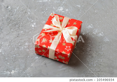 Wrapped christmas or other holiday handmade present in paper with colored ribbon. Present box, decoration of gift on table, top view with copy space Wrapped christmas or other holiday handmade present in paper with colored ribbon. Present box, decoration of gift on table, top view with copy space 105496934