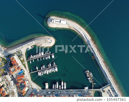 Aerial view of luxury sailing yachts and boats in yacht club near wooden piers. Top view of european city. Large boat parking near sea coast. Road to the lighthouse. Yachting in summer concept. 105497361