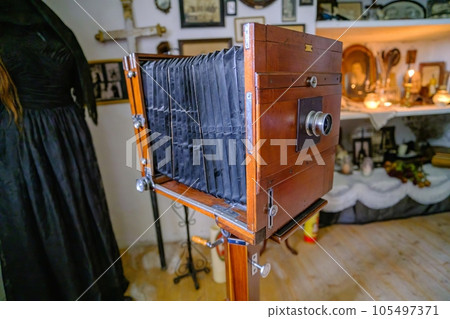 A very old camera on a shelf. Camera in working order. Camera on a wooden stand 105497371