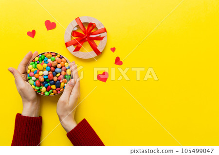Female hands with delicious candies in box on color background Female hands with delicious candies in box on color background 105499047
