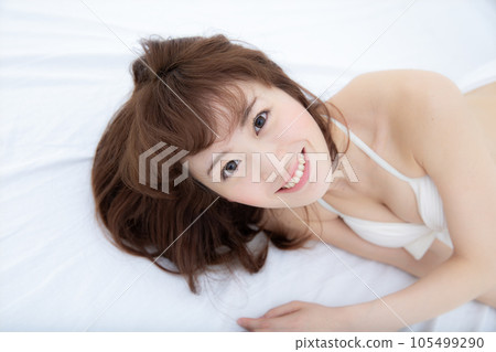 woman lying on white bed 105499290