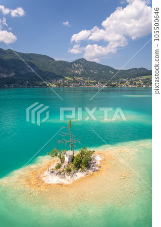 small island with a chapel on the lake Wolfgangsee, village of Sankt Gilgen and the mountains in the background, Austria 105500646