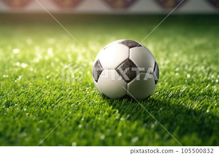 Classic soccer ball in sunset with typical black and white pattern, placed on stadium turf. Traditional football ball on the green grass lawn with copy space. 105500832