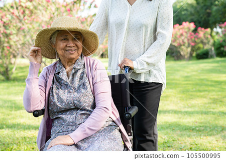 Caregiver help and care Asian elderly woman use walker with strong health while walking at park in happy fresh holiday. 105500995