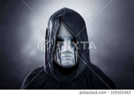 Spooky figure with hooded cape over dark misty background Spooky figure with hooded cape over dark misty background 105501483