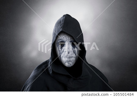 Spooky figure with hooded cape over dark misty background Spooky figure with hooded cape over dark misty background 105501484