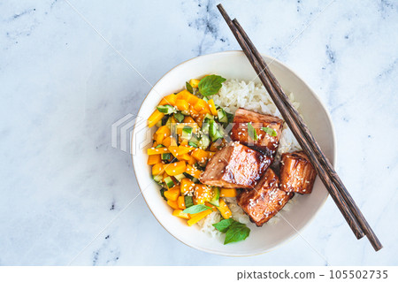 Teriyaki salmon with rice and mango in white bowl. Asian cuisine concept. Teriyaki salmon with rice and mango in white bowl. Asian cuisine concept. 105502735