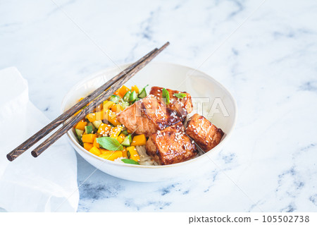 Teriyaki salmon with rice and mango in white bowl. Asian cuisine concept. 105502738