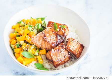 Teriyaki salmon with rice and mango in white bowl. Asian cuisine concept. Teriyaki salmon with rice and mango in white bowl. Asian cuisine concept. 105502740