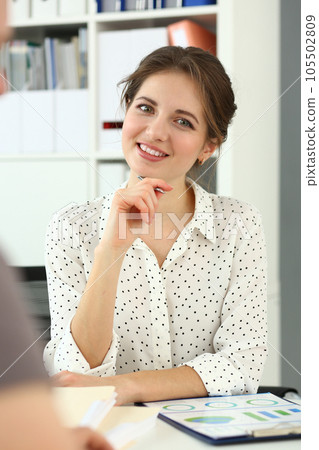 Portrait of smiling woman at work table with documents Portrait of smiling woman at work table with documents 105502809