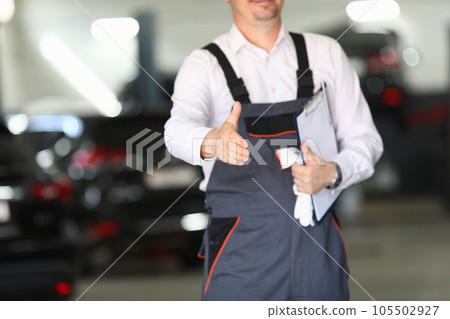 Auto service mechanic greets client with handshake 105502927