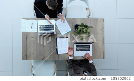 Two successful smiling businessmen are working on a laptop. view from above 105502962