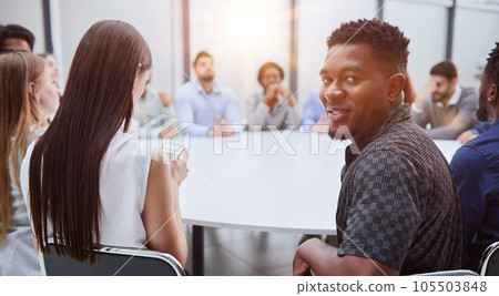 young African American man posing for the camera while sitting at a table young African American man posing for the camera while sitting at a table 105503848