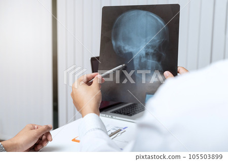 Medical and health care concept. Doctor explaining x-ray results to patient while sitting at the table in office. Medical and health care concept. Doctor explaining x-ray results to patient while sitting at the table in office. 105503899
