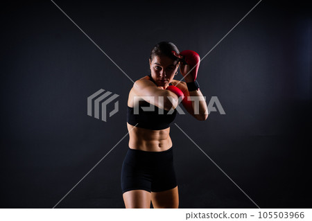 Portrait of a female mixed martial arts fighter with a bandage and gloves on her hands. 105503966