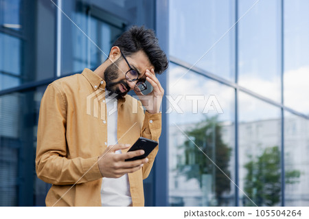 Upset businessman received message with bad news, hispanic man outside office alarm clock cheated and bankrupt, man unhappy with achievement results walking in city. Upset businessman received message with bad news, hispanic man outside office alarm clock cheated and bankrupt, man unhappy with achievement results walking in city. 105504264
