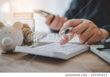 close up The business person is sitting on a calculator with a graph in the office of finance accounting concept close up The business person is sitting on a calculator with a graph in the office of finance accounting concept 105504815