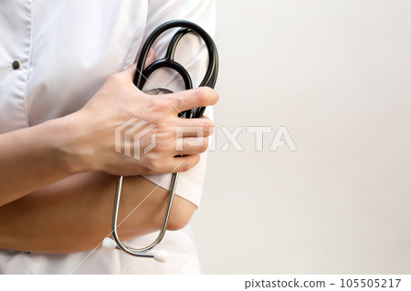 Medical stethoscope in the hands of a female doctor, close-up copy space 105505217