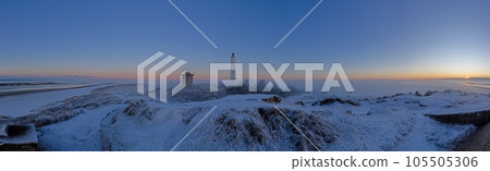 Panorama over the dunes and lighthouse of the Danish coastal resort of Blavand at sunrise 105505306