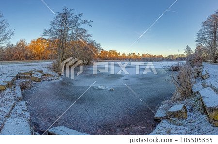 Panoramic image of frozen lake at frosty temperature during sunrise Panoramic image of frozen lake at frosty temperature during sunrise 105505335
