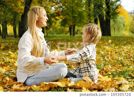 The family has fun in the park. Girl and mother sit on a blanket and rest 105505728