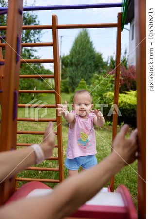 little baby girl with mother on slide in playground 105506215
