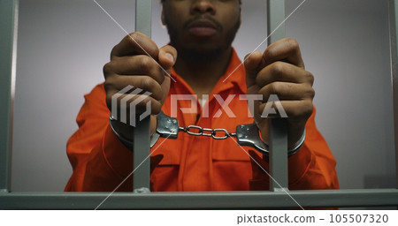 Prisoner keeps hands in handcuffs on jail cell Prisoner keeps hands in handcuffs on jail cell 105507320