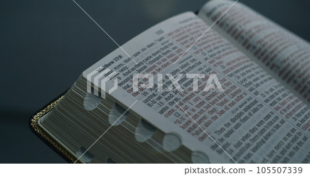 Prisoner in orange uniform reads Bible in prison cell 105507339