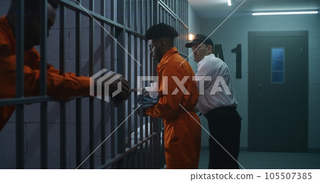 Prison employee brings new prisoner in jail cell Prison employee brings new prisoner in jail cell 105507385