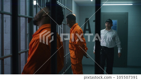 Criminals stand face to cell with hands behind Criminals stand face to cell with hands behind 105507391