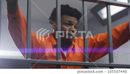 Man leans hands on jail cell bars and kneads neck 105507440