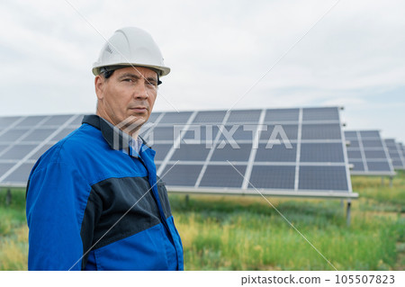 Service Engineer man standing in front of solar panels. Technician maintenance solar cells on Solar Energy Plant under morning sunlight. Technology solar energy renewable Service Engineer man standing in front of solar panels. Technician maintenance solar cells on Solar Energy Plant under morning sunlight. Technology solar energy renewable 105507823