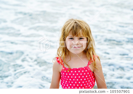 Portrait of Happy Child, Little Preschool Girl in Swimmsuit Running And Jumping In The Waves During Summer Vacation On Exotic Tropical Beach. Family Journey On Ocean Coast. 105507901