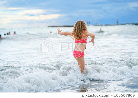 Happy Child, Little Preschool Girl in Swimmsuit Running And Jumping In The Waves During Summer Vacation On Exotic Tropical Beach. Family Journey On Ocean Coast. Happy Child, Little Preschool Girl in Swimmsuit Running And Jumping In The Waves During Summer Vacation On Exotic Tropical Beach. Family Journey On Ocean Coast. 105507909
